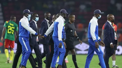 Security escourt Ethiopian referee Bamlak Tessema Weyesa (3rd R) off the field during the Africa Cup of Nations (CAN) 2021 round of 16 football match between Cameroon and Comoros at Stade d'Olembe in Yaounde on January 24, 2022. (Photo by Kenzo Tribouillard / AFP)